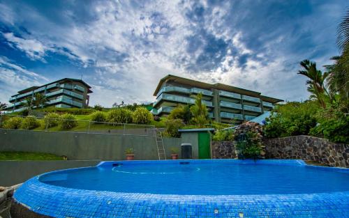 a large blue swimming pool in front of a building at Lake Arenal Condos in Naranjos Agrios