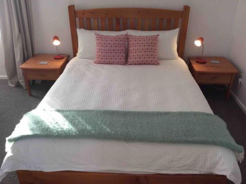 a bedroom with a large bed with two night stands at The Gables B&B in Ohakune
