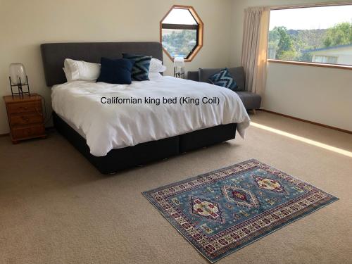 a bedroom with a bed with a rug and a window at Harbour View Retreat Mangonui in Mangonui