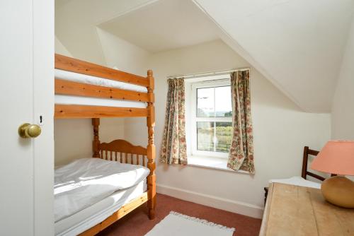 a bedroom with a bunk bed and a window at Cardross Holiday Cottages in Arnprior