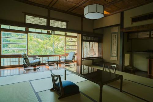 a living room with a table and chairs at Ochiairo in Izu