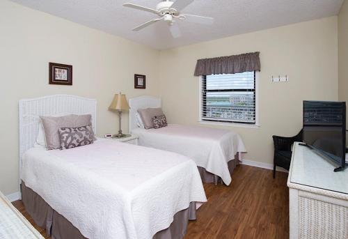1 Schlafzimmer mit 2 Betten und einem Flachbild-TV in der Unterkunft Sunswept 601 Condo in Orange Beach