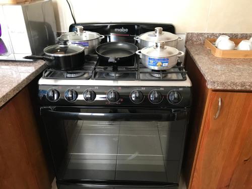 a stove with two pots and pans on top of it at cómodo first floor in Santiago de los Caballeros