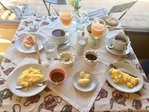 a table with plates of food and glasses of orange juice at Finca el Maitén Hotel Boutique in San Rafael