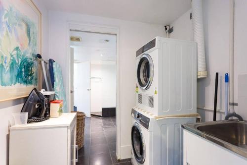 a kitchen with a washer and dryer next to a sink at The Beach Shack 3BR Waterfront Resort, Own WIFI in Trinity Beach