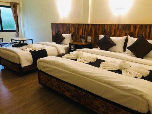 a group of three beds in a room at Khao Sok Nature Place - SHA Certified in Khao Sok