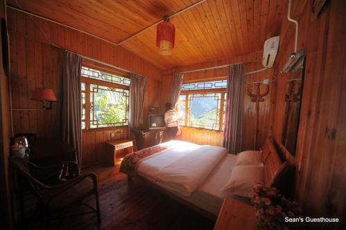 a bedroom with a bed in a wooden room at Tiger Leaping Gorge Sean’s Spring Guesthouse in Shangri-La