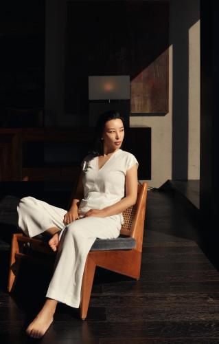 a woman in a white dress sitting in a chair at Yakamoz Erhai Hotel in Dali
