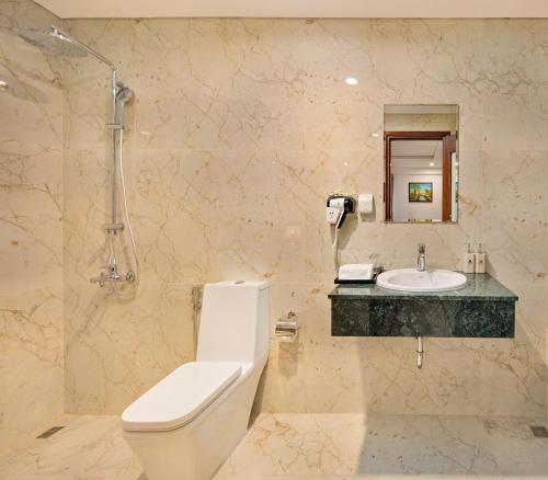 a bathroom with a toilet and a sink at Eden Ocean View Hotel Da Nang in Da Nang