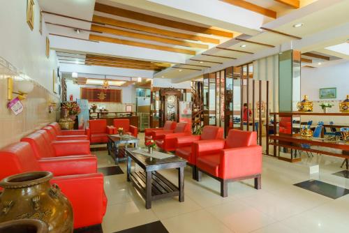 a waiting room with red chairs and tables at RedDoorz at Sedayu 1 Parapat in Parapat