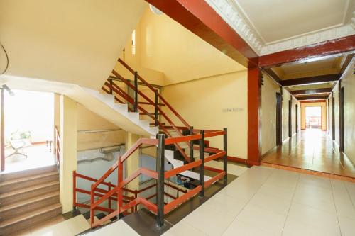 a spiral staircase in a room with wooden floors at RedDoorz at Sedayu 1 Parapat in Parapat