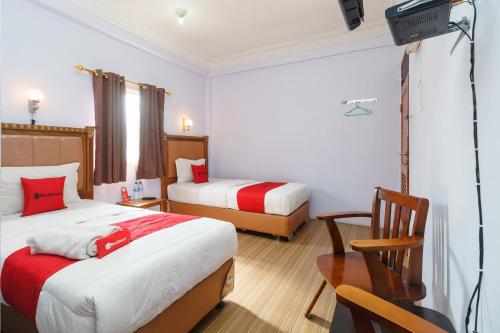 a hotel room with two beds and a television at RedDoorz at Sedayu 1 Parapat in Parapat