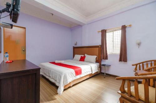 a bedroom with a bed and a dresser in it at RedDoorz at Sedayu 1 Parapat in Parapat