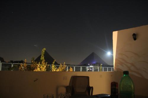 a view of the pyramids from a balcony at night at Farida Pyramids Boutique Hotel in Cairo