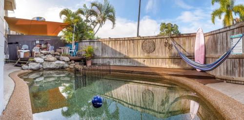 
a pool of water with a statue of a fish in it at Castaways Backpackers Cairns in Cairns
