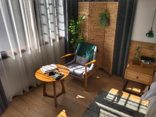 a living room with a chair and a table at BaHaoBieYuan in Fenghuang