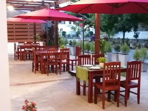 a group of tables and chairs with red umbrellas at Villa Chitchareune 2 in Luang Prabang