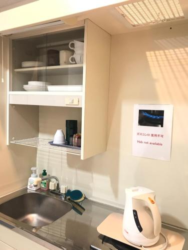 a kitchen with a sink and a counter top at ROSE ROOM in Fukuyama