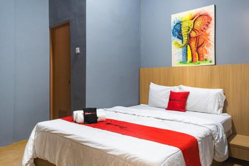 a bedroom with a large bed with red pillows at RedDoorz Plus @ Otista Raya Ciputat in Tangerang