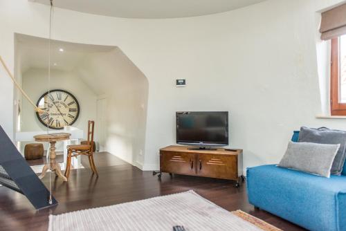 a living room with a blue couch and a tv at De Lievensmolen in Damme