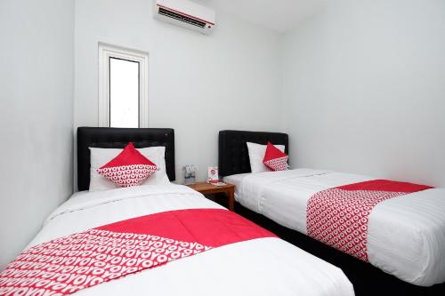 two beds sitting next to each other in a room at Super OYO 1565 Palebon Residence in Semarang