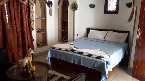 ルクソールにあるLeyla Eco Resort Queen Suitesのベッドルーム(ベッド1台、テーブル付)