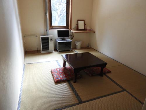 a living room with a table and a window at Brocken Hutte in Hakuba