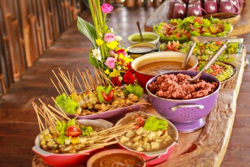 een buffet van verschillende soorten eten op een tafel bij Dragonfly Village in Ubud