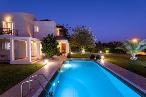 una piscina frente a una casa por la noche en Afrodite Classico Villa, en Kolymbia