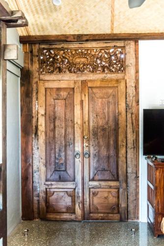 a wooden door in a room with a tv at Bali at the Bay in Nelson Bay
