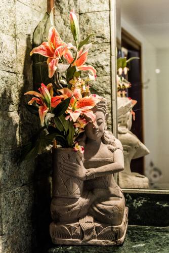 a statue of a person with flowers in it at Bali at the Bay in Nelson Bay