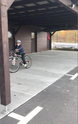 a person riding a bike in a parking lot at Hausboot Elandi in Bitterfeld