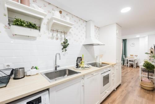 eine Küche mit weißen Schränken und einem Waschbecken in der Unterkunft Apartment Sol Gran Vía in Madrid