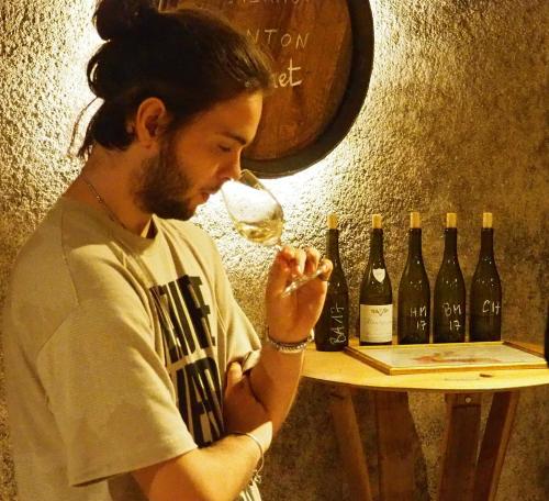 a man drinking a glass of wine next to wine bottles at Casa di Pierina in Poggibonsi