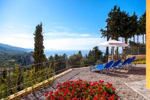 a patio with chairs and an umbrella and flowers at Ble on Blue in Athanion