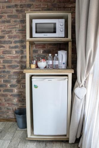 a microwave on top of a refrigerator in a room at Opstal Guestfarm in Potchefstroom