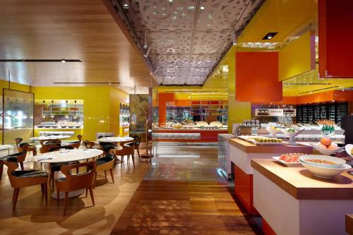 首尔首尔乐天酒店的拥有桌椅和黄色墙壁的餐厅