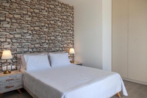 a bedroom with a bed and a brick wall at Ble on Blue in Athanion