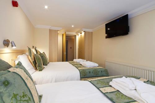 a hotel room with two beds and a flat screen tv at Burbage Holiday Lodge Apartment 1 in Blackpool
