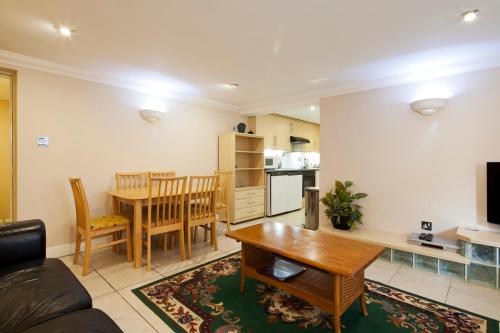 a living room with a table and a kitchen at Burbage Holiday Lodge Apartment 1 in Blackpool