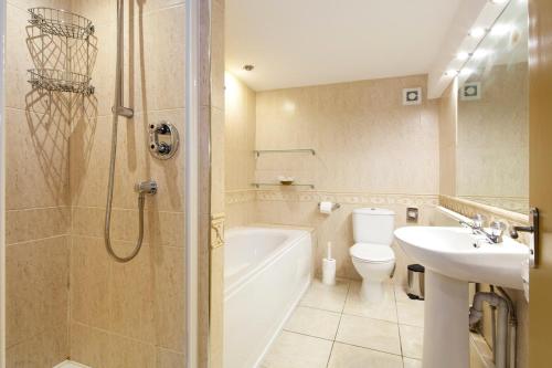 La salle de bains est pourvue d'un lavabo, de toilettes et d'une douche. dans l'établissement Burbage Holiday Lodge Apartment 1, à Blackpool