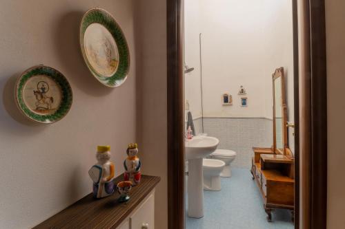 La salle de bains est pourvue de toilettes et d'une plaque murale. dans l'établissement Casa Museo A' Rina, à Belpasso