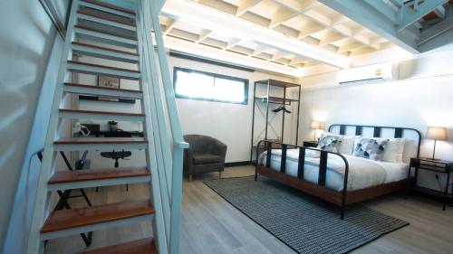 een slaapkamer met een bed en een wenteltrap bij Airee Premier Residence in Bangkok