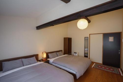 a bedroom with two beds and a mirror at Coto in Miyazu