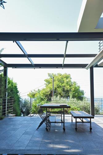 a picnic table and a bench on a patio at Elia Seafront Villa in Elia