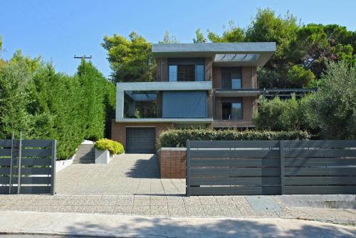 a house with a fence in front of it at Elia Seafront Villa in Elia
