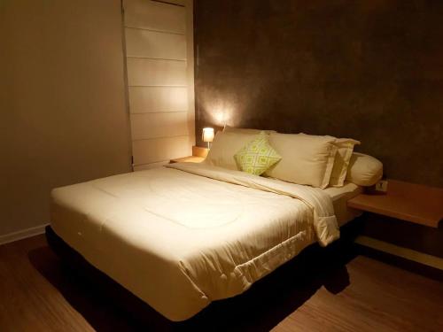 ein Schlafzimmer mit einem großen Bett mit weißer Bettwäsche und Kissen in der Unterkunft Graha Padma Avonia in Semarang