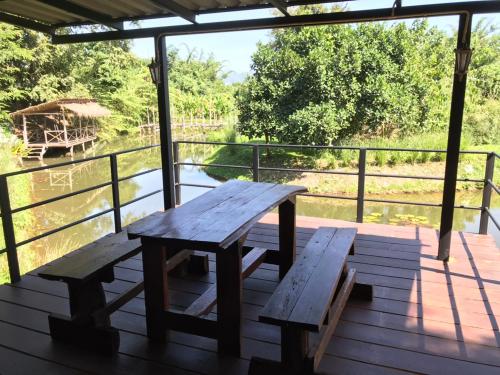 a picnic table on a deck with a view of the water at Dreamhome Chiangdao in Chiang Dao