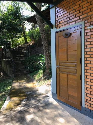 a wooden garage door on a brick building with stairs at Dreamhome Chiangdao in Chiang Dao
