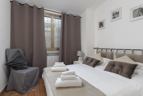a bedroom with two beds and a chair at Take You Rome - Vatican Apartment in Rome
